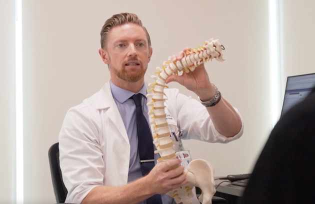 A patient receiving expert guidance on spinal conditions during a consultation for Scoliosis Treatment in Abu Dhabi.